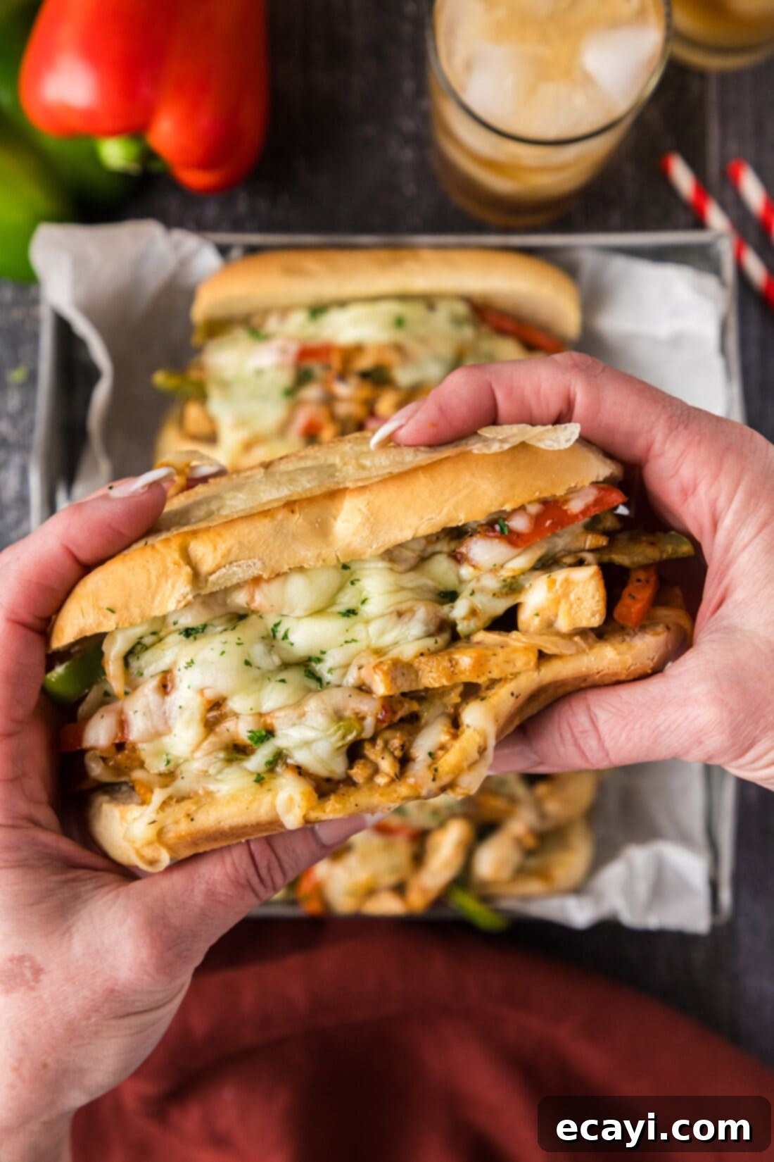 Philly Chicken Cheesesteak 11 A hand holding a perfectly assembled Chicken Philly Cheesesteak, showing off its generous filling and golden bun.