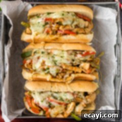 Philly Chicken Cheesesteak 12 Close up photo of three Chicken Philly Cheesesteaks in a tray, highlighting the rich filling and perfectly melted cheese.