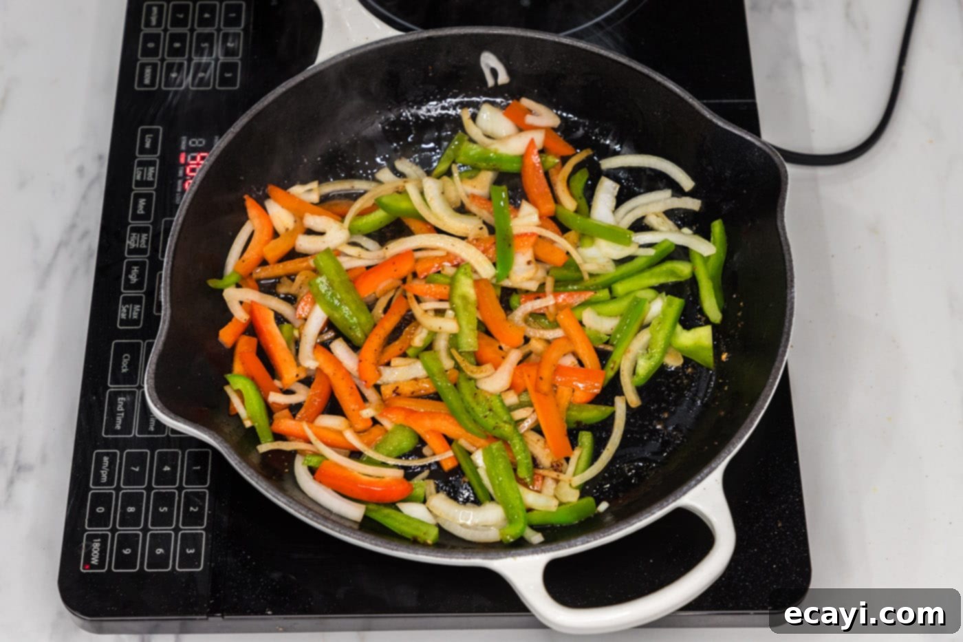 Philly Chicken Cheesesteak 7 Vibrantly sliced bell peppers and onions softening in a skillet, absorbing the pan's rich flavors.