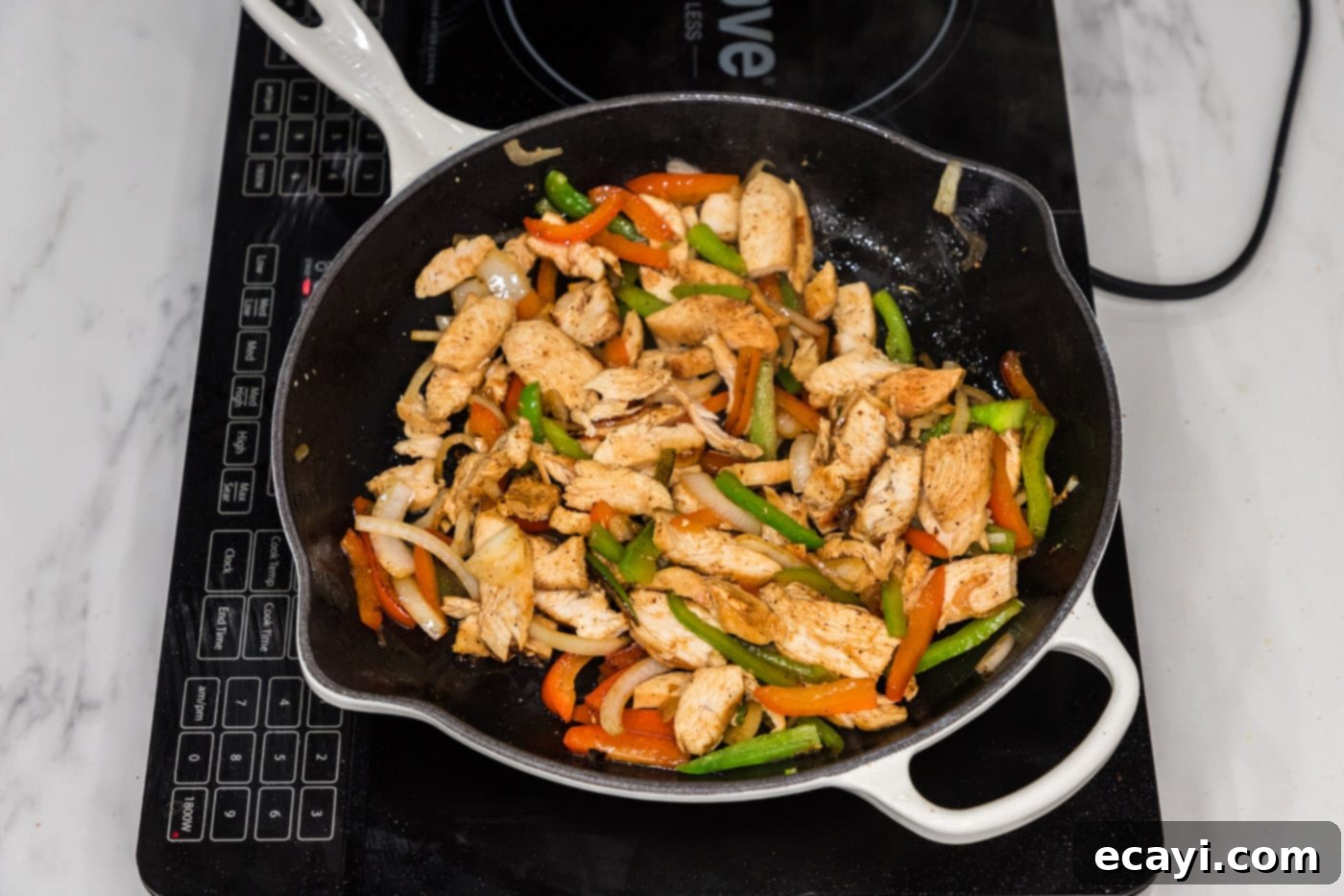 Philly Chicken Cheesesteak 8 Adding tender, sliced chicken to a skillet filled with sautéed bell peppers and onions, ready to be combined.