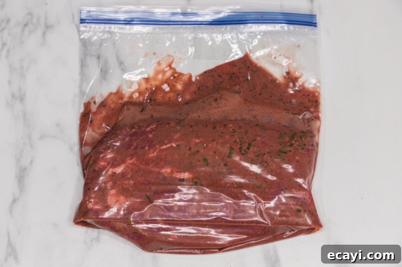 The Butcher's Secret Steak 6 marinating flat iron steak in a gallon zip top bag