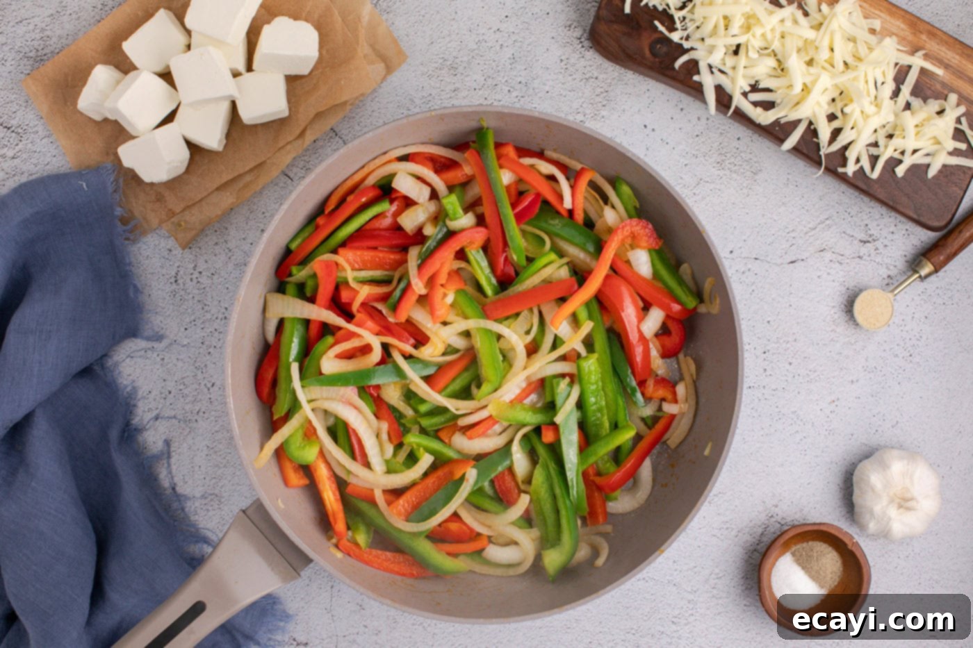 Cheesy Philly Chicken Bake 5 sliced bell peppers and onions in a skillet