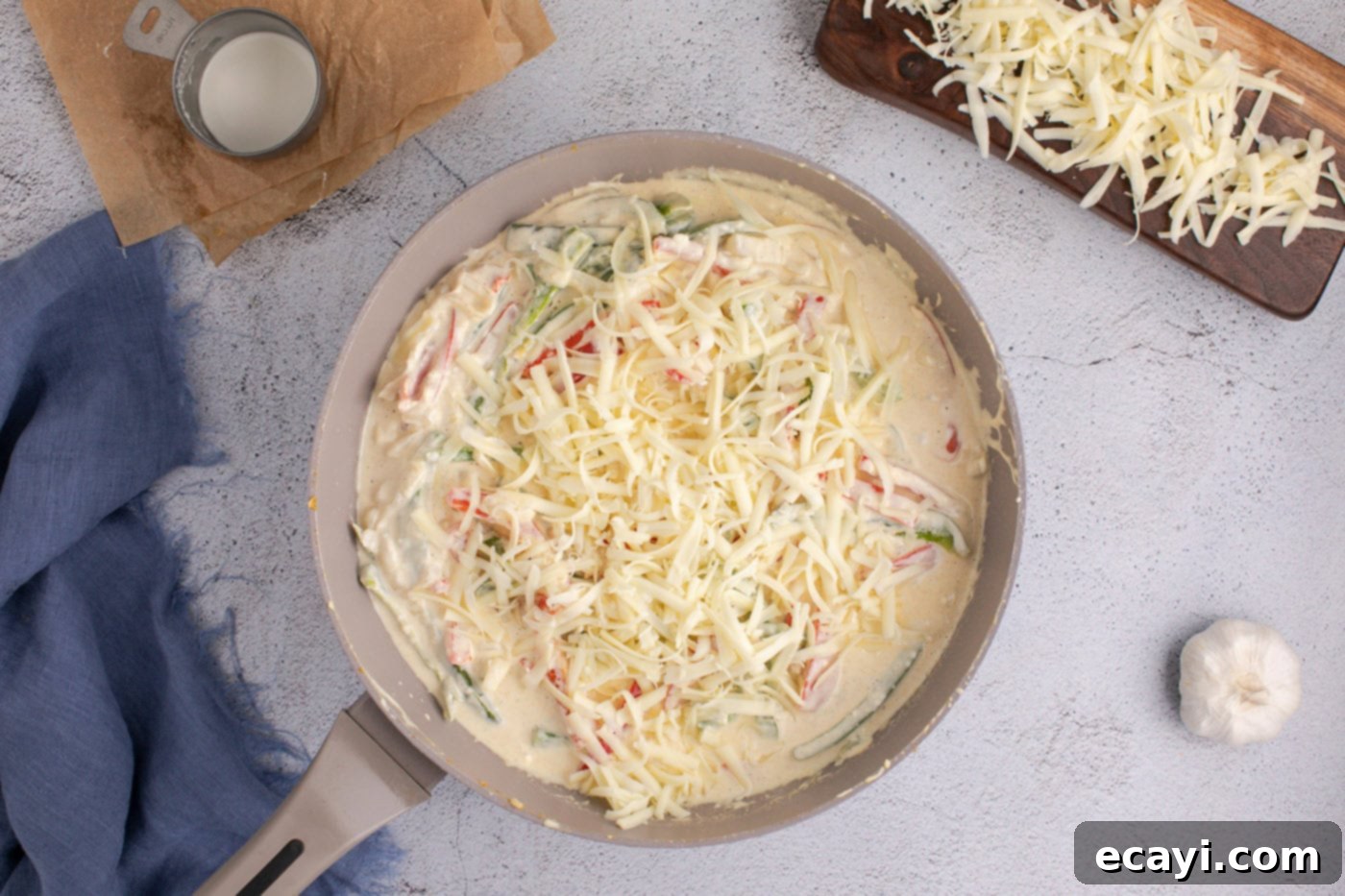 Cheesy Philly Chicken Bake 8 adding pepperjack cheese to skillet with sauteed peppers and onions