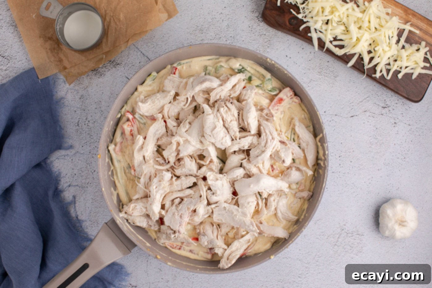 Cheesy Philly Chicken Bake 9 shredded chicken in skillet with creamy sauce, peppers, and onions