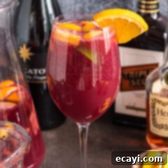 Mexican Fiesta Sangria 13 Close up photo of a glass of Mexican Inspired Sangria garnished with an orange wedge and pineapple chunks