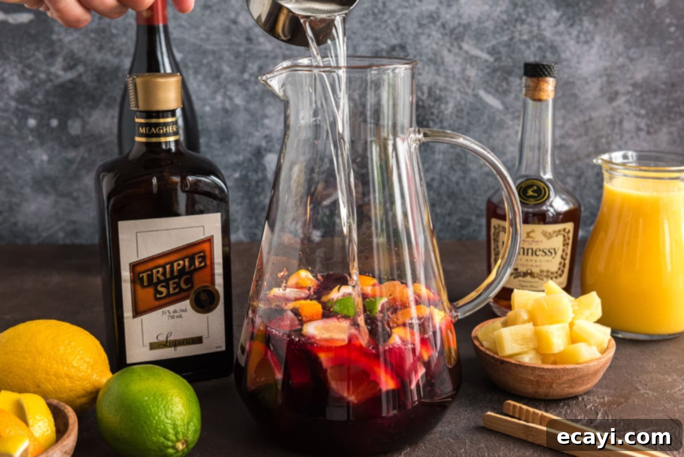 Mexican Fiesta Sangria 8 Pouring triple sec orange liqueur into the sangria base with red moscato, brandy, and fruit