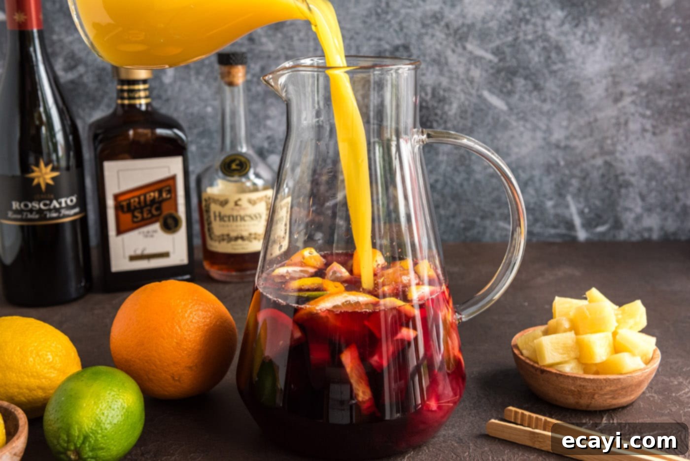 Mexican Fiesta Sangria 9 Adding orange juice to the pitcher containing red wine, brandy, triple sec, and fresh fruit for Mexican sangria