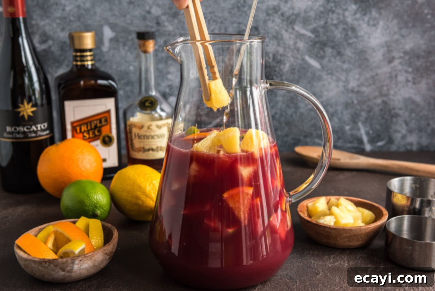 Mexican Fiesta Sangria 10 Adding pineapple chunks to the mixed Mexican Sangria ingredients in a pitcher