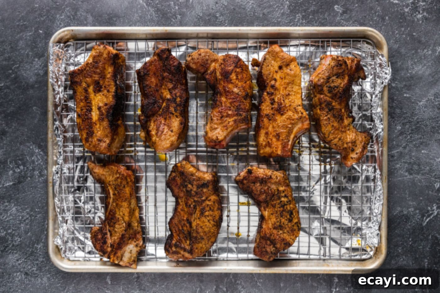 Down-Home Country Ribs 10 pork ribs on a wire rack over a baking sheet, ready for the oven