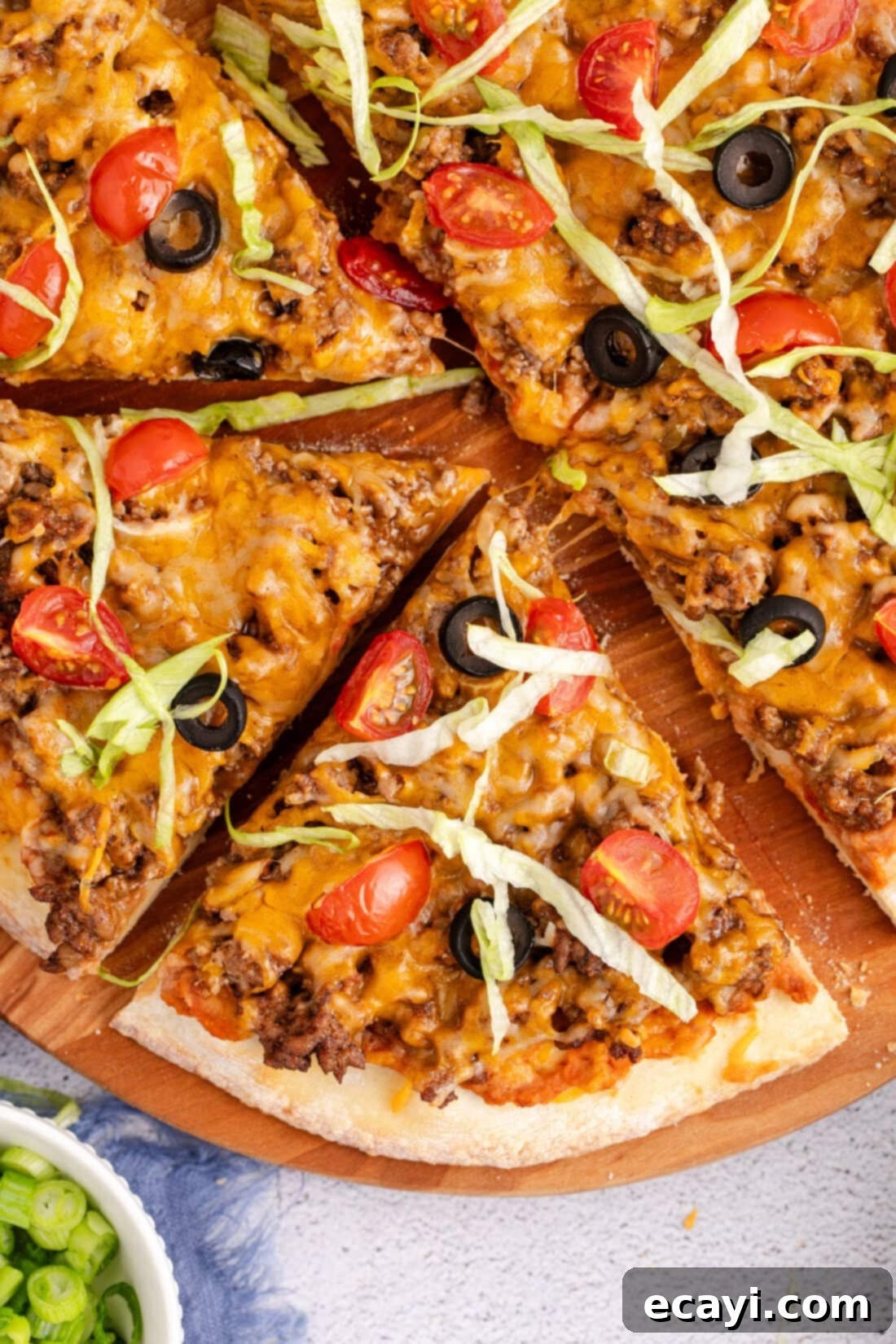 Fiesta Taco Pizza 3 Close up photo of individual Taco Pizza slices, showcasing the layers of meat, cheese, and fresh toppings.