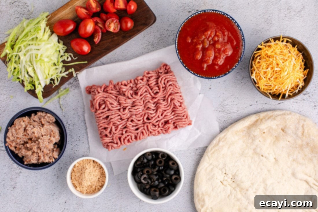 Fiesta Taco Pizza 4 A colorful flat lay of all the fresh ingredients needed for Taco Pizza, including ground beef, taco seasoning, refried beans, salsa, pizza crust, cheese, and various toppings.