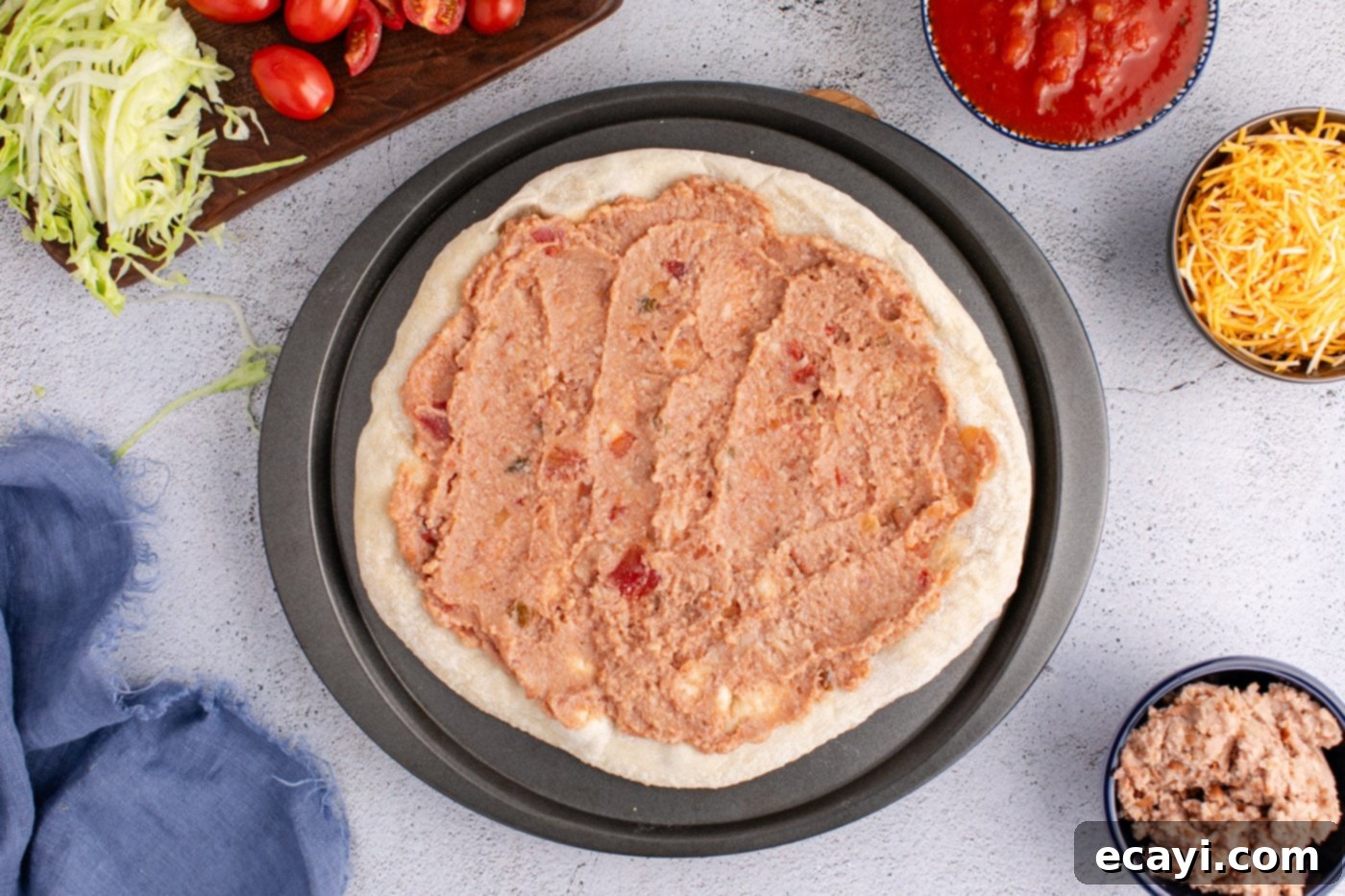 Fiesta Taco Pizza 7 Layer of refried beans and salsa spread over a pre-made pizza crust.