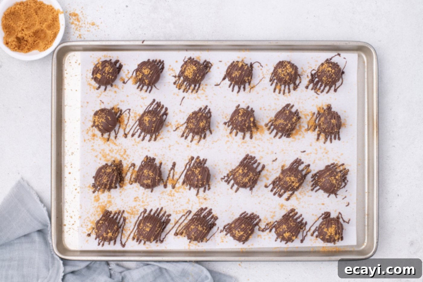 Peanut Butter Truffle Bites 11 Beautifully drizzled and garnished Nutter Butter balls cooling on a baking sheet