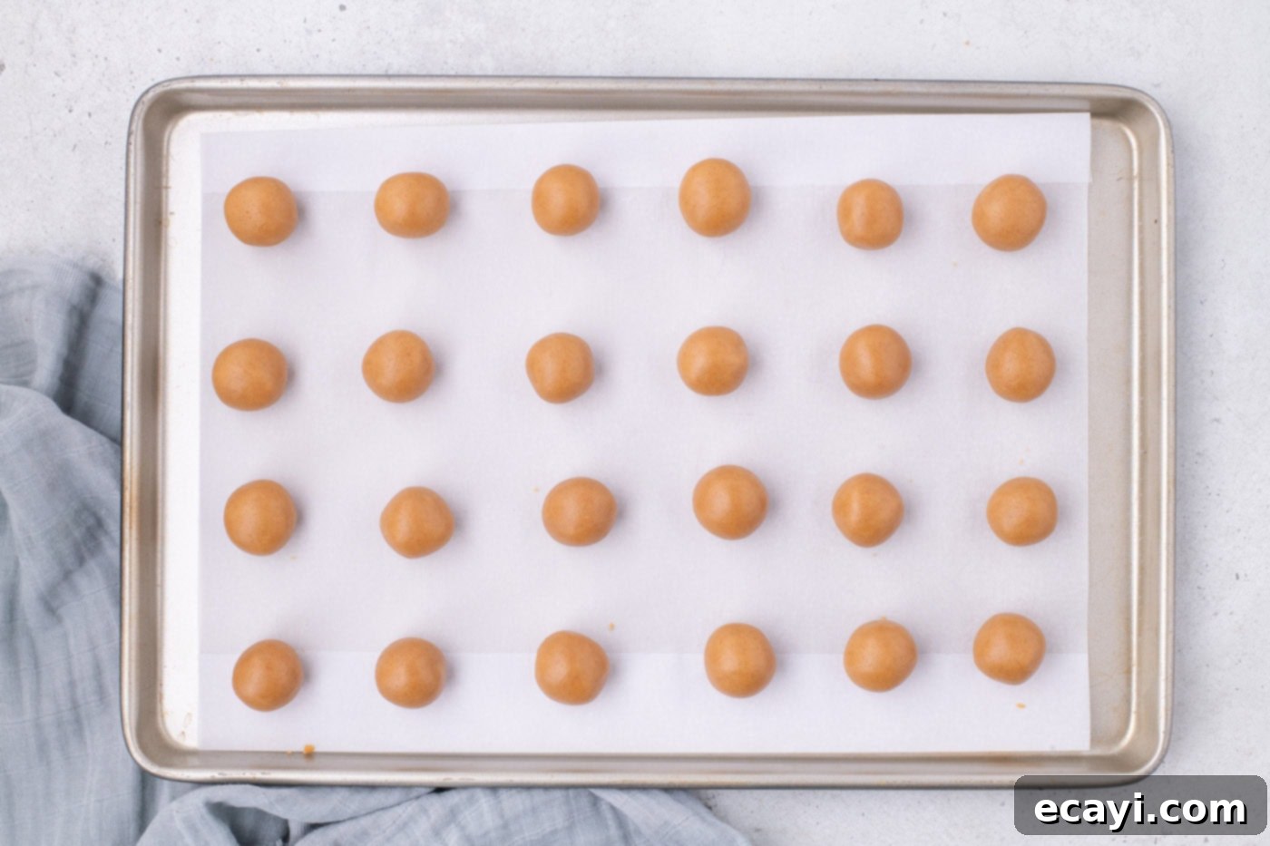 Peanut Butter Truffle Bites 8 Nutter Butter cookie balls neatly arranged on a baking sheet, ready for freezing