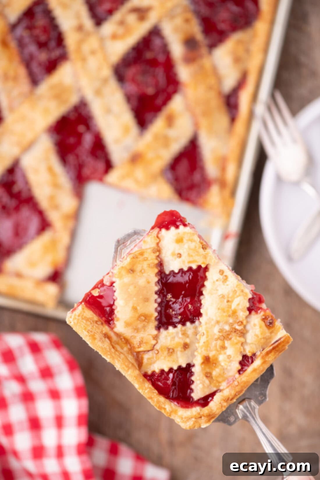 Sheet Pan Cherry Pie 18 Spatula holding a square of Cherry Slab Pie above the rest of the Cherry Slab Pie