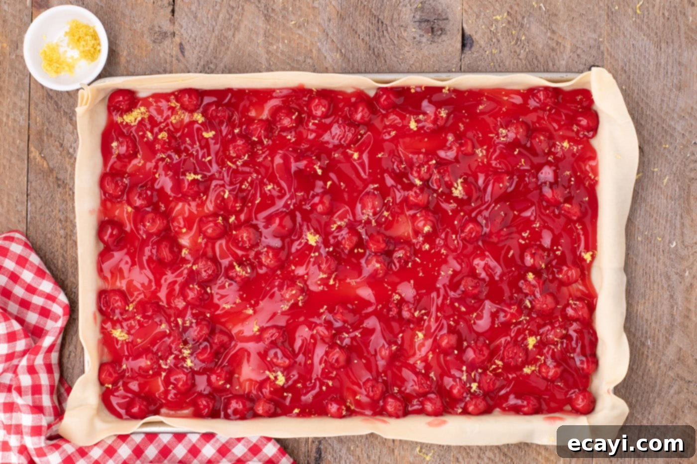 Sheet Pan Cherry Pie 9 cherry pie filling on top of pie crust in a jelly roll pan