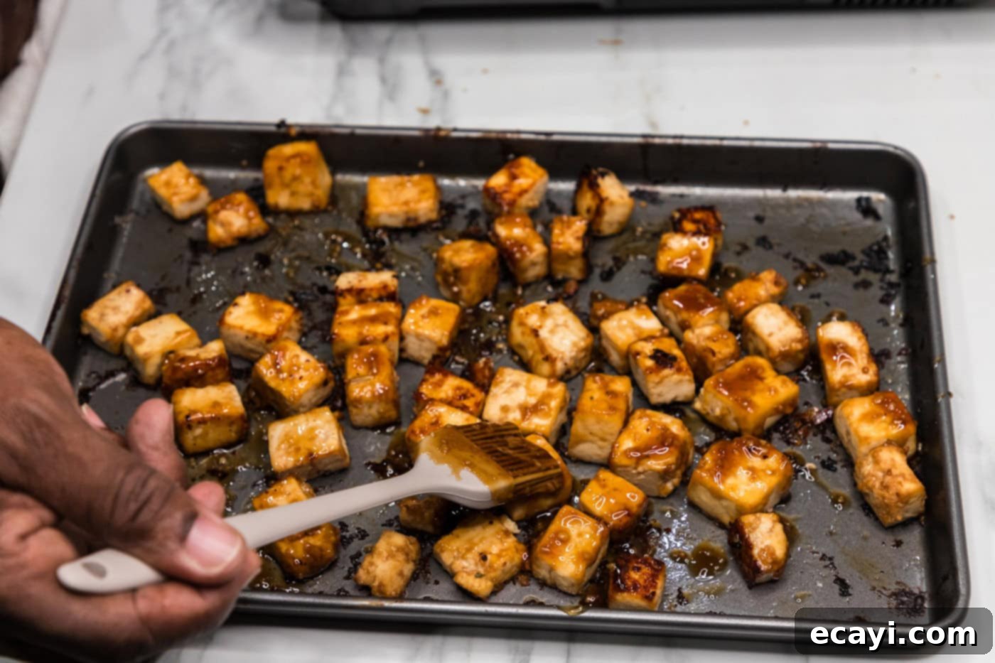 Sticky Honey Garlic Tofu 12 brushing tofu cubes with honey garlic sauce