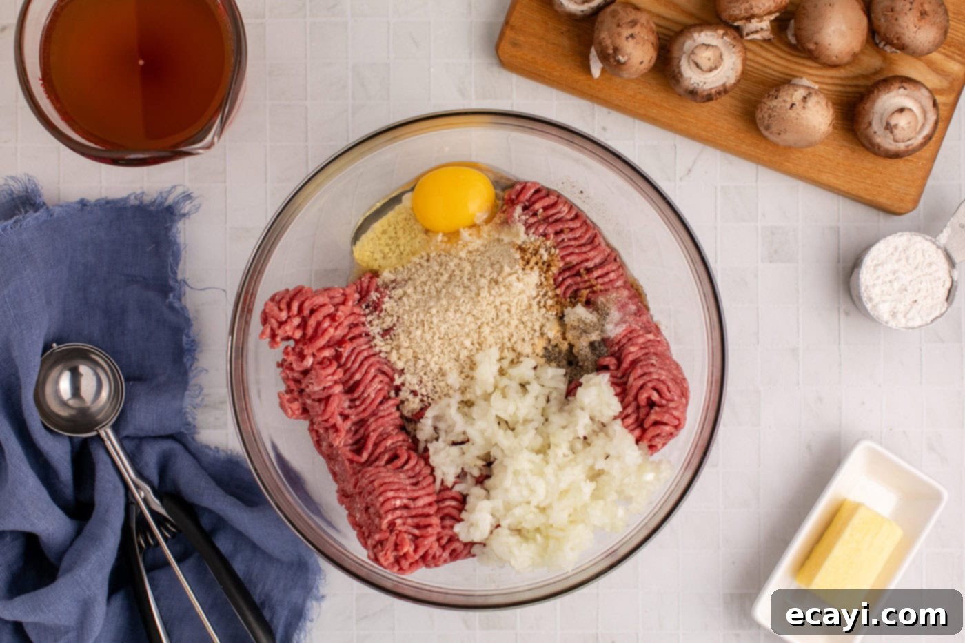 Hearty Salisbury Steak Meatballs 5 meatball ingredients in a mixing bowl being thoroughly combined by hand