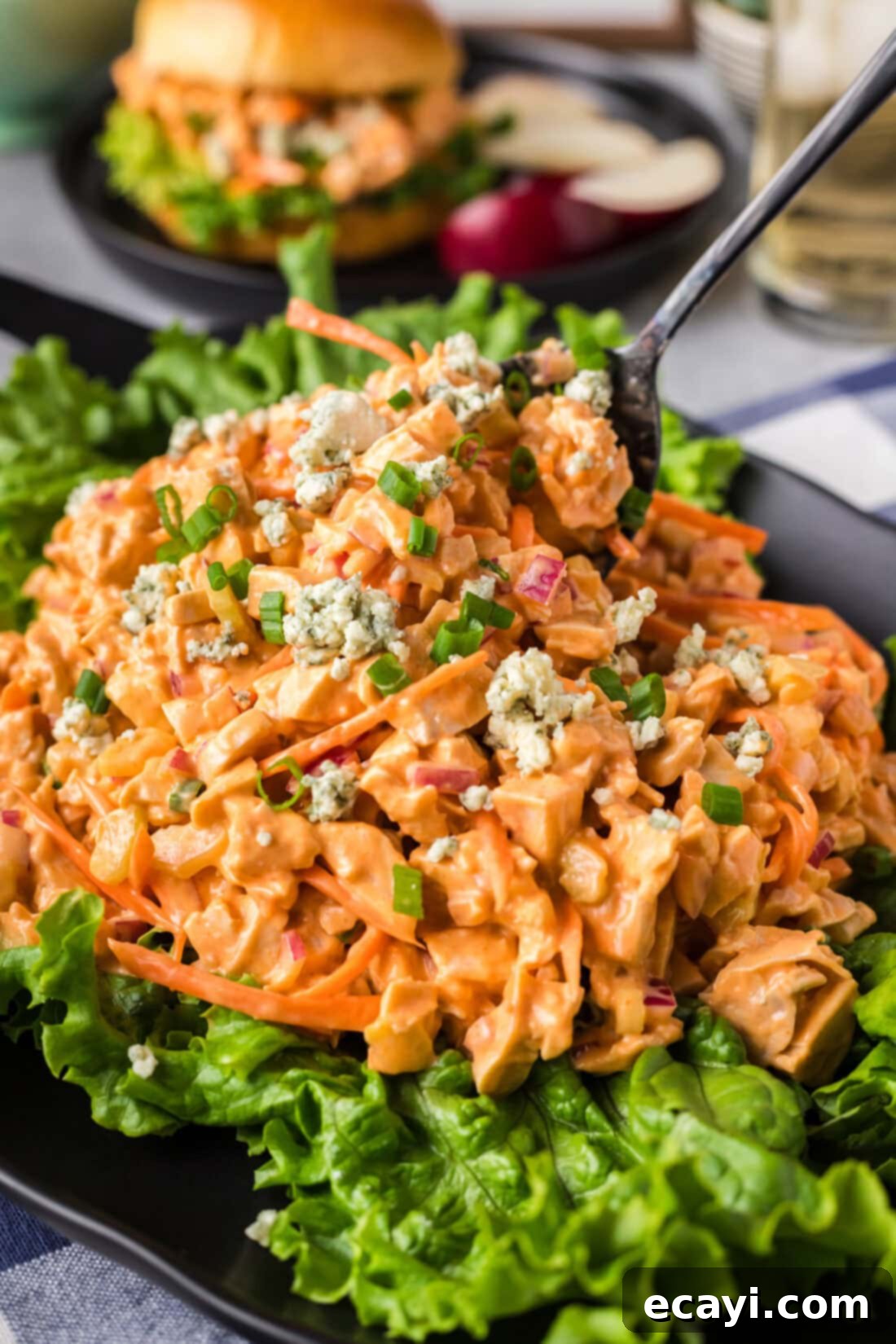 Fiery Buffalo Chicken Bowl 2 Creamy Buffalo Chicken Salad served on a bed of fresh lettuce with a serving spoon