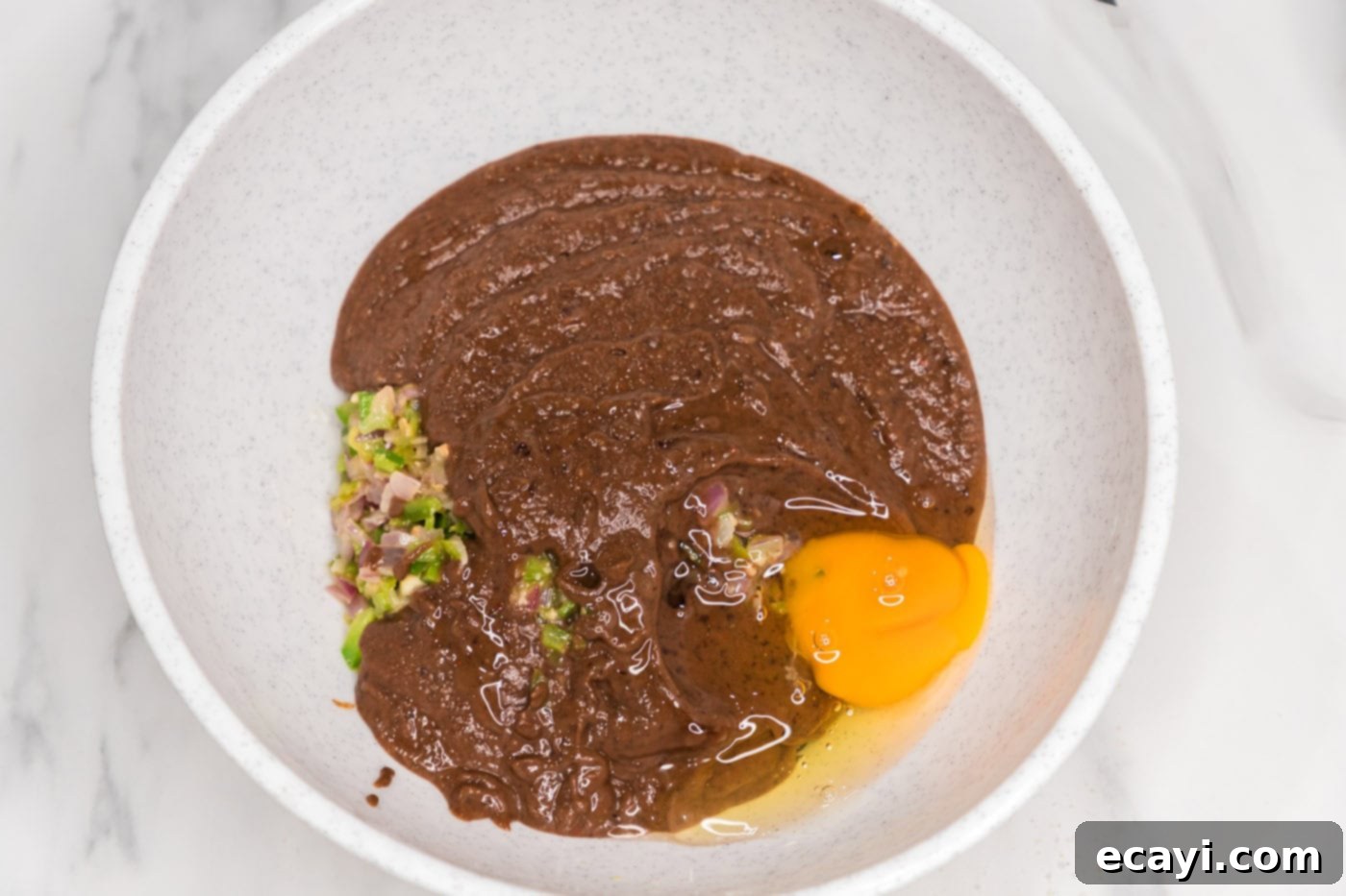Signature Black Bean Burger 7 blended black bean mixture added to bowl with an egg, sauteed veggies, and whole black beans