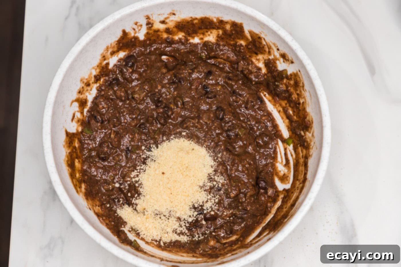 Signature Black Bean Burger 8 breadcrumbs added to bowl with black bean mixture