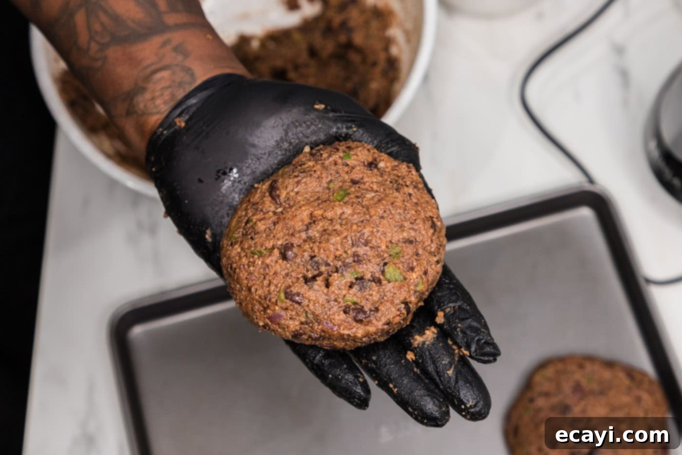 Signature Black Bean Burger 10 hand holding black bean burger patty