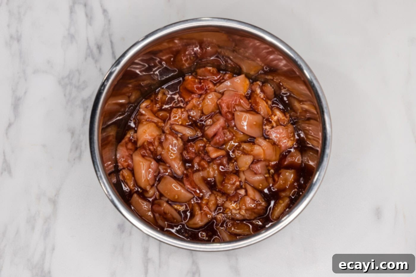 Bourbon Glazed Instant Pot Chicken 6 Bite-sized chicken pieces thoroughly coated in a flavorful bourbon sauce, ready for pressure cooking.