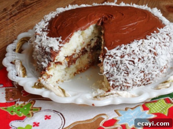 Blissful Almond Coconut Snowflake Cake 12 A close up photo of an almond joy coconut snowflake cake with a slice removed, revealing the moist layers and rich frosting.