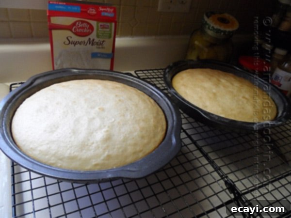 Blissful Almond Coconut Snowflake Cake 8 Two freshly baked cake layers cooling on a wire rack after being removed from the oven.