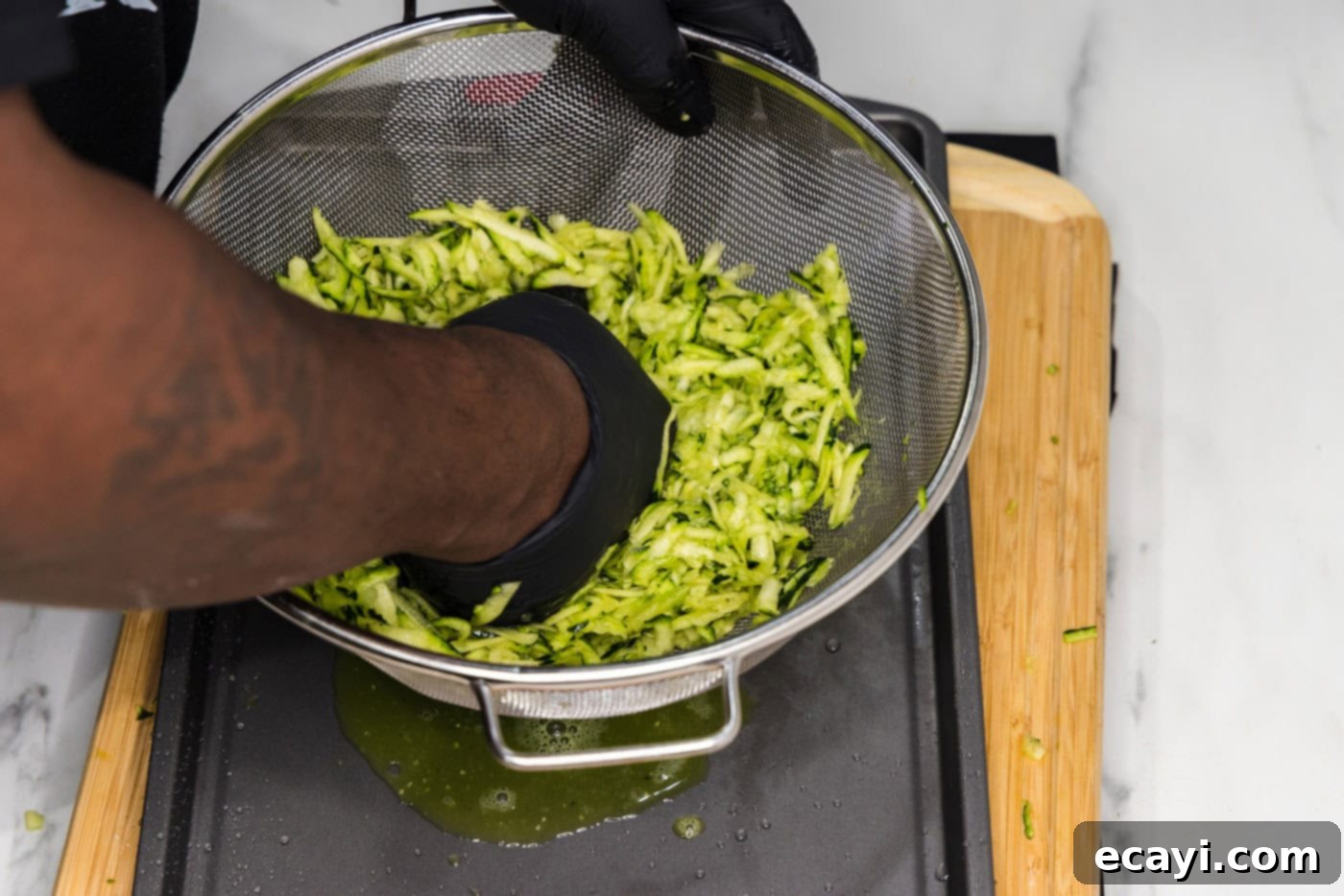 Crispy Zucchini Delights 6 squeezing moisture out of zucchini in a colander
