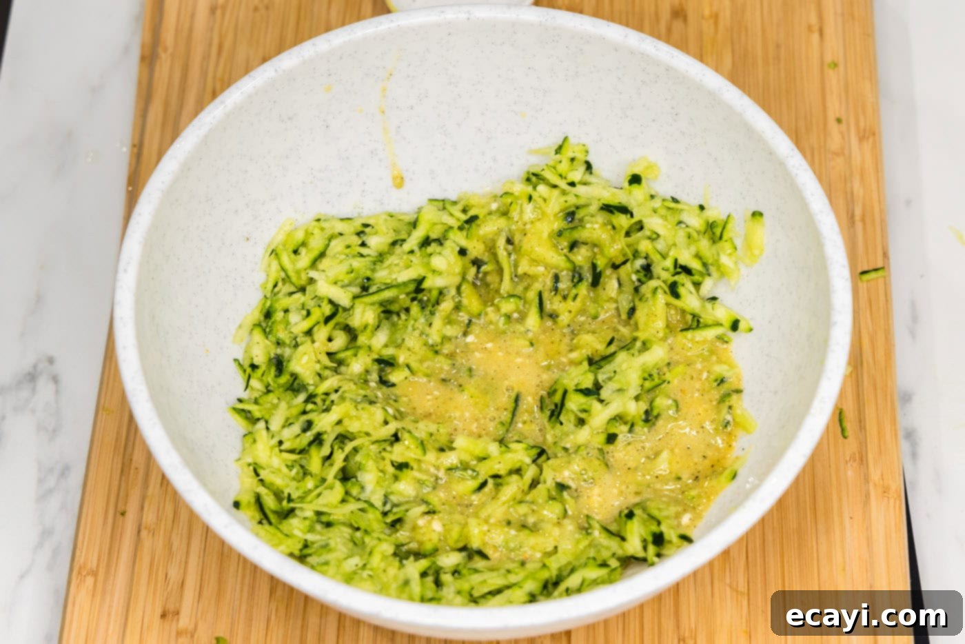 Crispy Zucchini Delights 7 egg added to shredded zucchini in a bowl