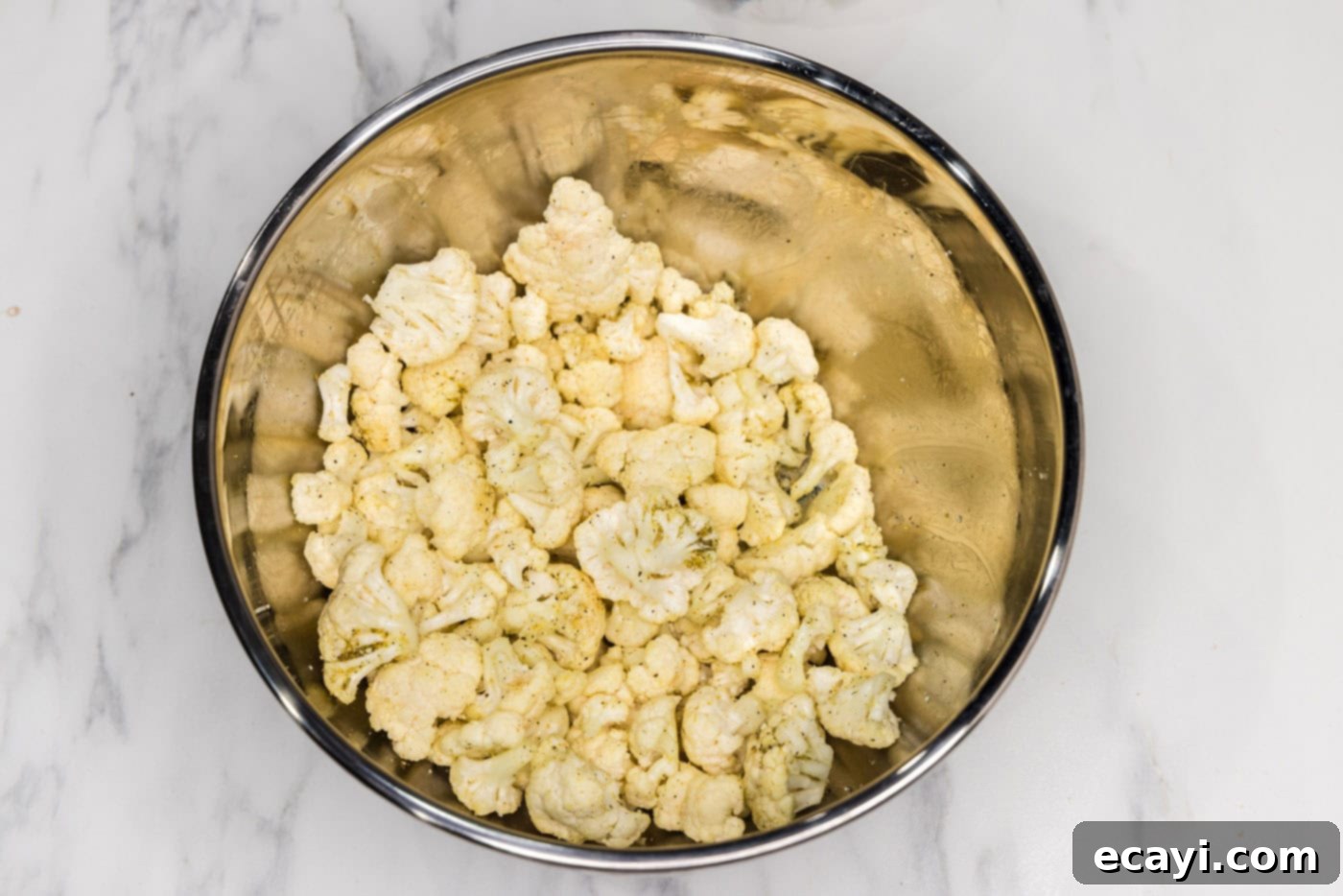 Zesty Cauliflower Medley 6 Seasoned cauliflower florets in a bowl, ready for roasting.
