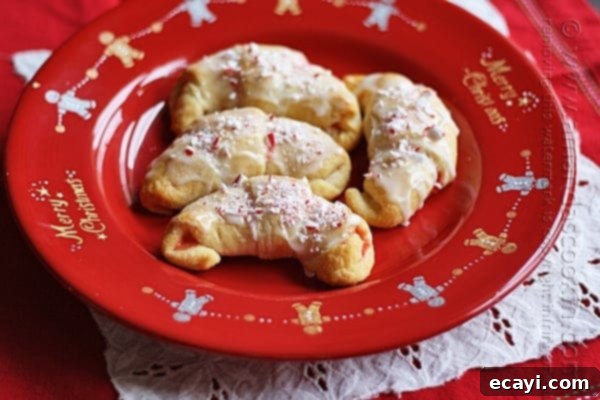 Festive White Chocolate Candy Cane Cookies 2 A close up overhead of several white chocolate candy cane crescents beautifully arranged on a vibrant red plate.