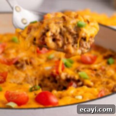 Taco Mac 'n' Cheese 13 Close up photo of a spoonful of Taco Macaroni and Cheese being lifted from the skillet.