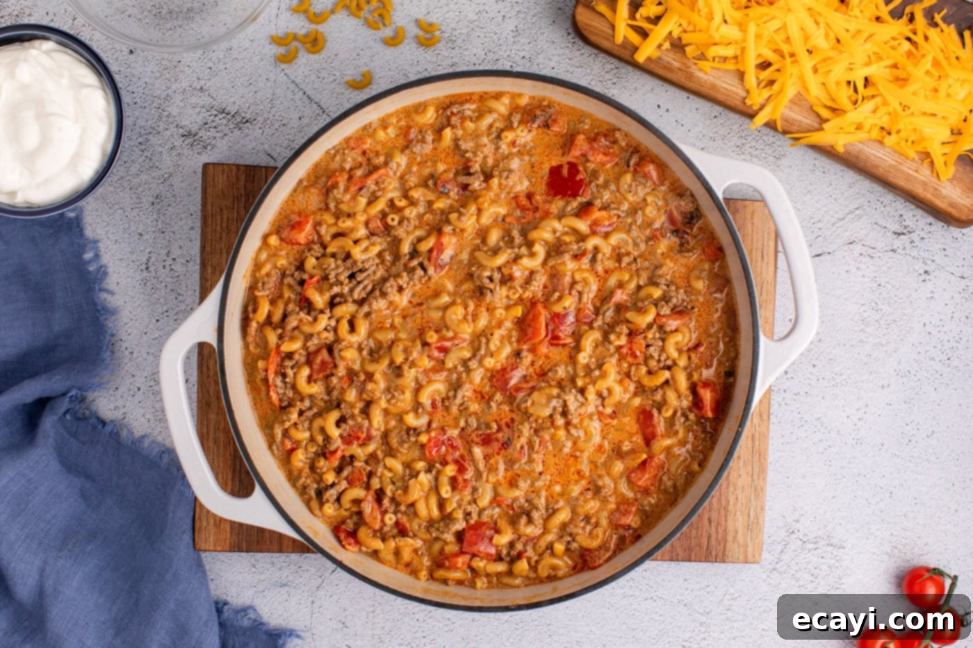 Taco Mac 'n' Cheese 9 stirred taco mac in a skillet, showing cooked noodles and thickened sauce.