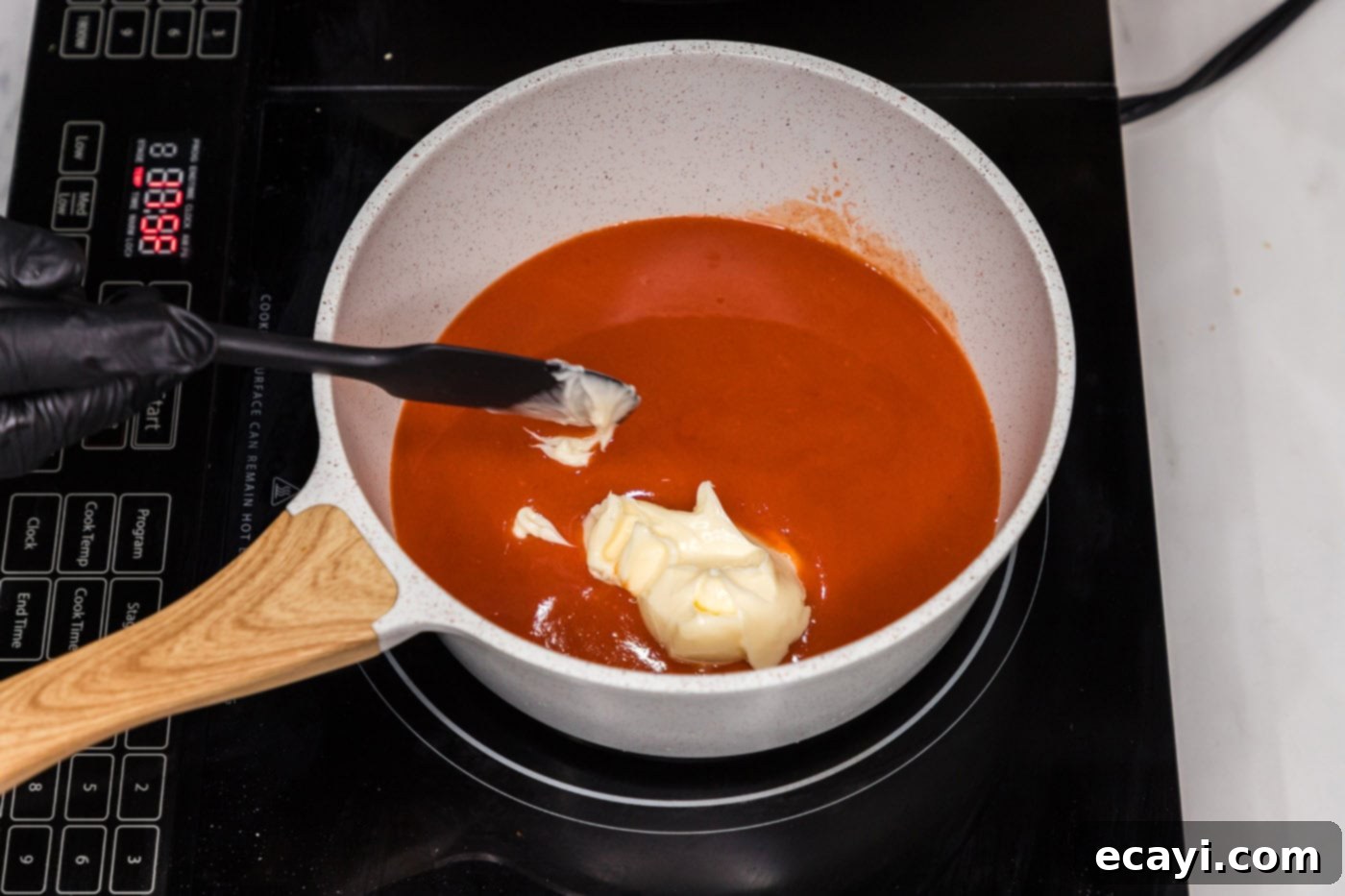Signature Buffalo Chicken Strips 12 A saucepan on the stove containing melted butter and hot sauce, gently simmering.