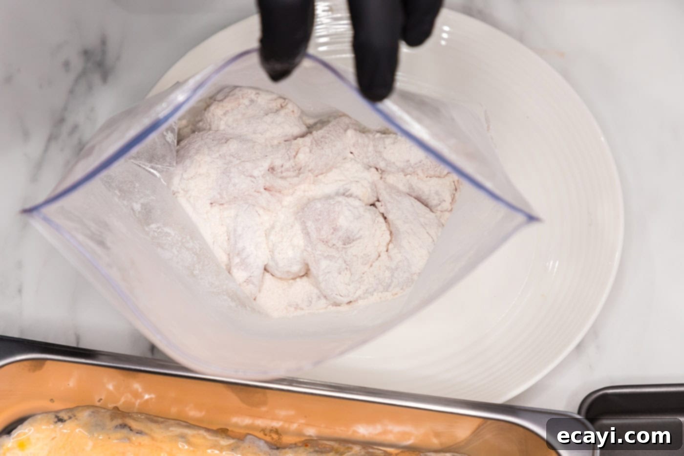 Signature Buffalo Chicken Strips 6 Flour-dredged chicken tenderloins inside the sealed bag, ready for the next breading step.
