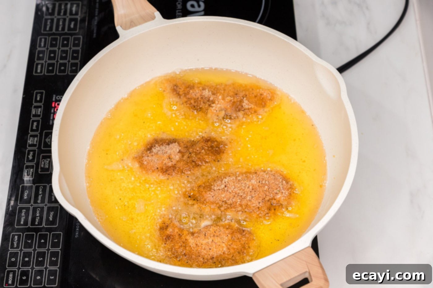 Signature Buffalo Chicken Strips 10 Buffalo Chicken Tenders actively frying in a skillet of hot oil, turning golden brown.