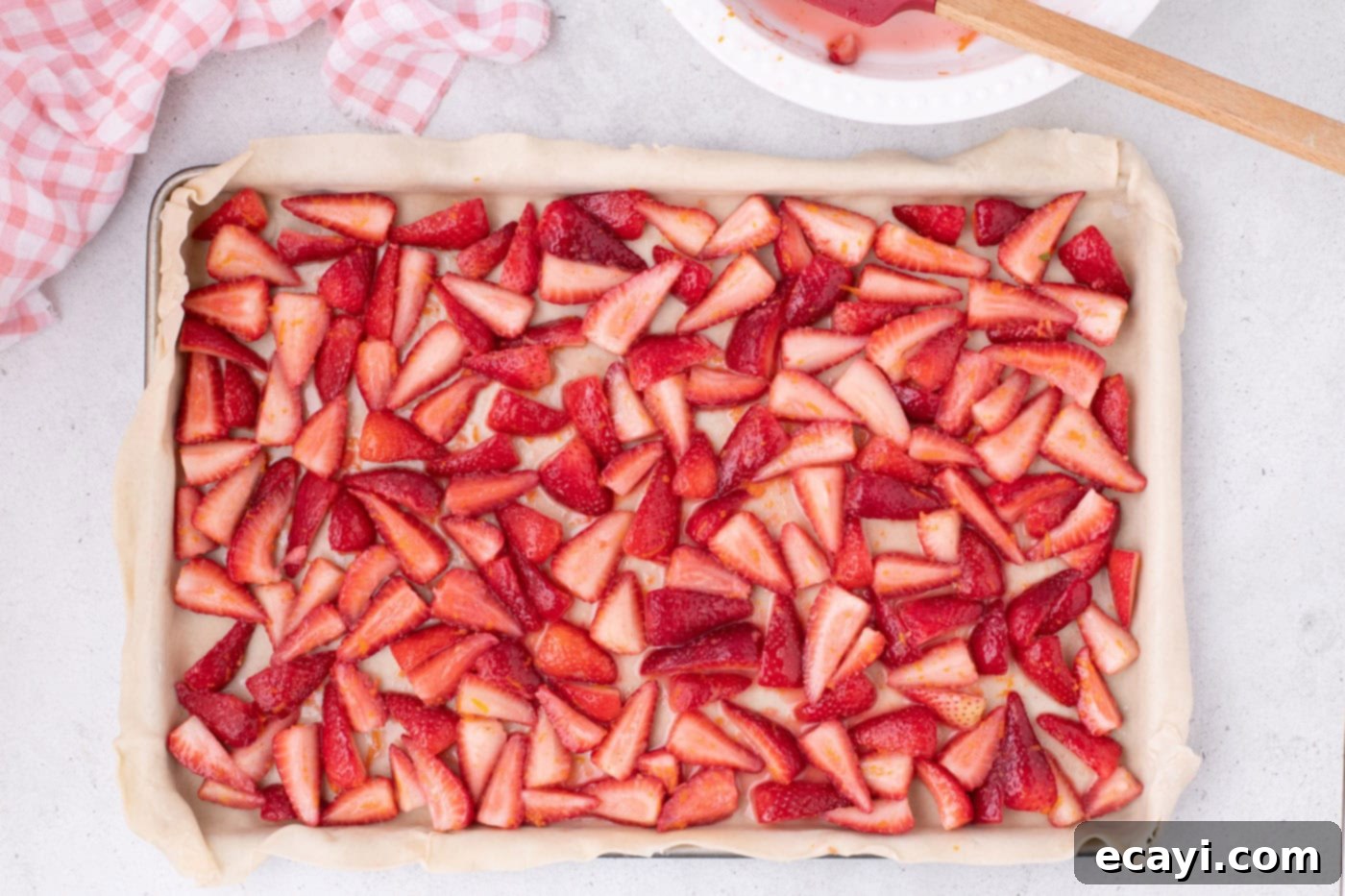 Strawberry Sheet Pan Delight 11 sliced strawberries and their juices spread evenly on top of the pie crust in a jelly roll pan