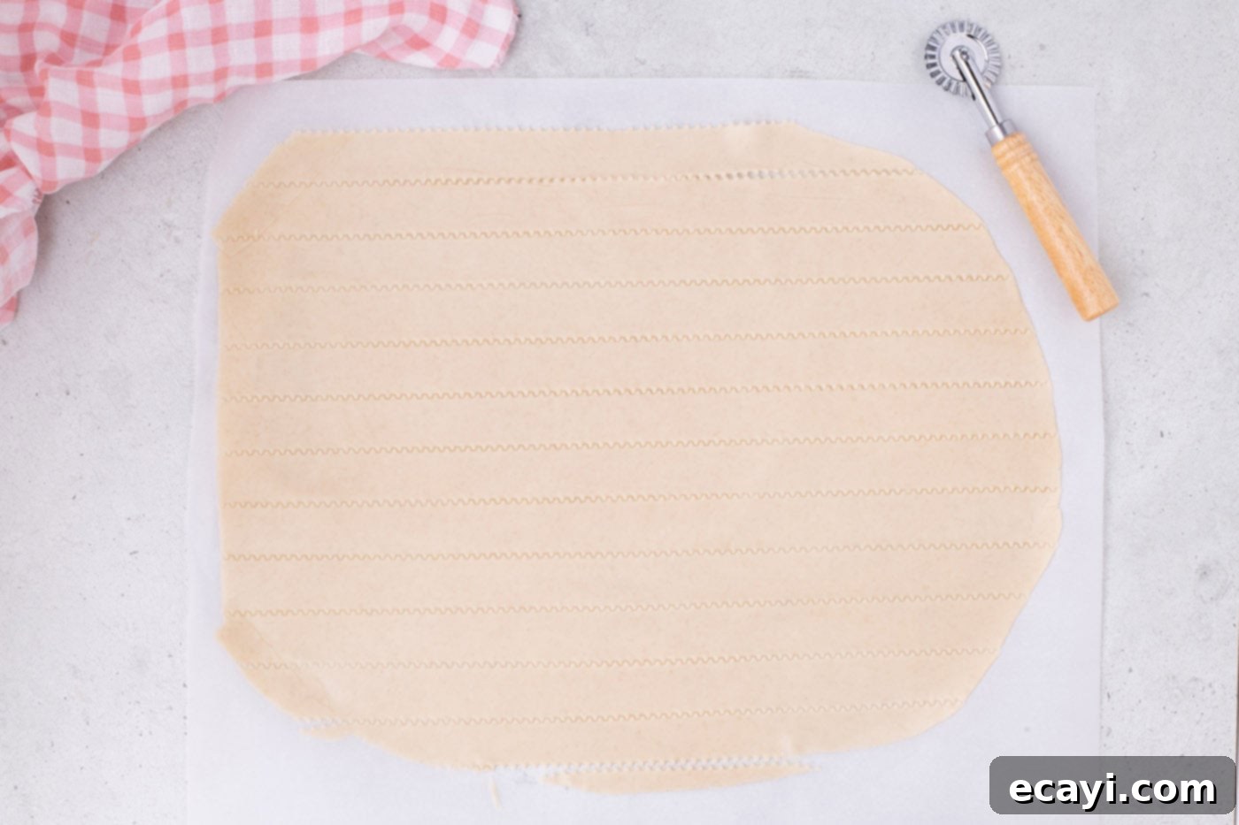 Strawberry Sheet Pan Delight 12 slicing pie crust into even strips with a pizza cutter and ruler