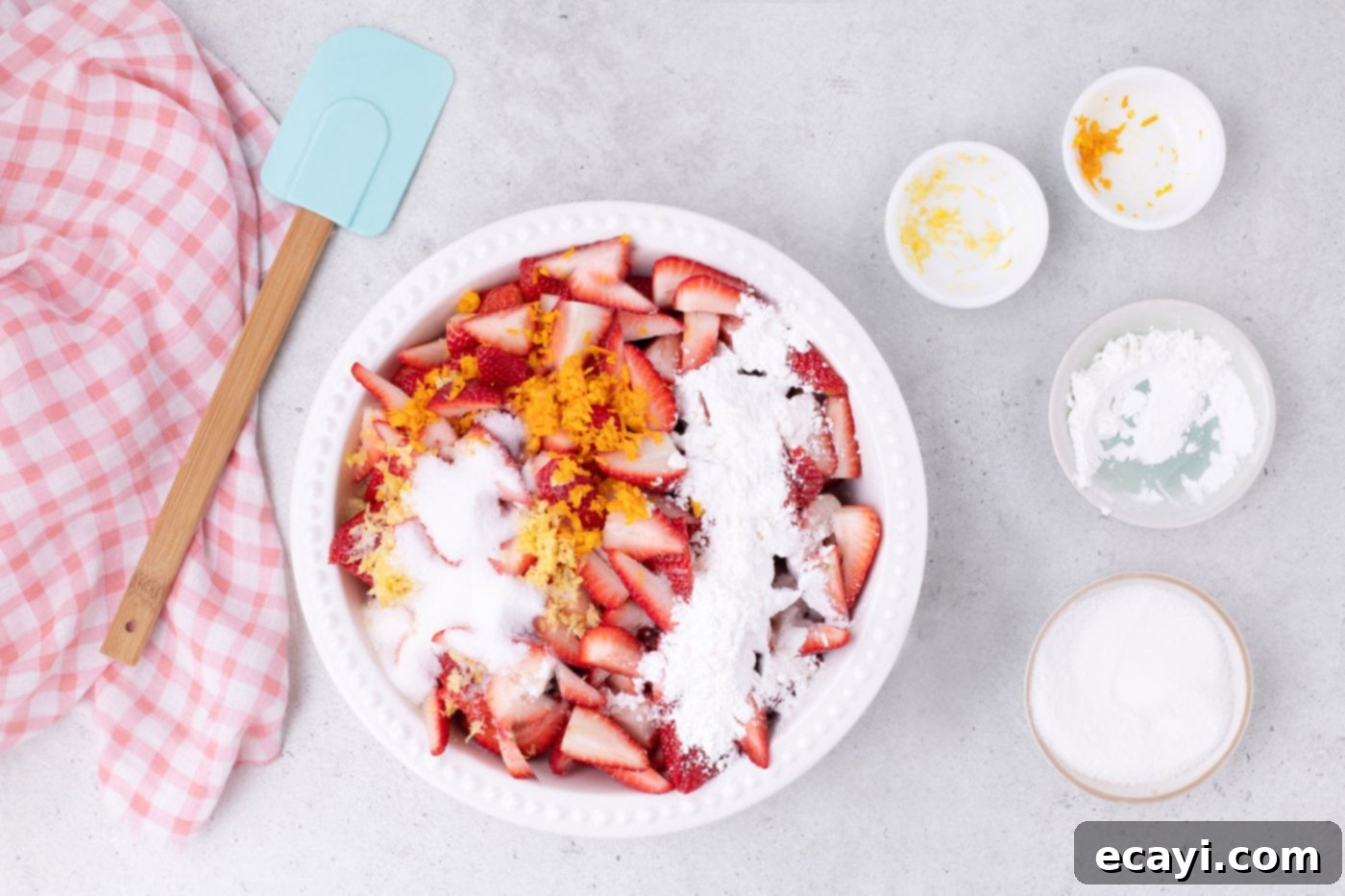 Strawberry Sheet Pan Delight 5 sugar, orange zest, and lemon zest over sliced strawberries in a bowl