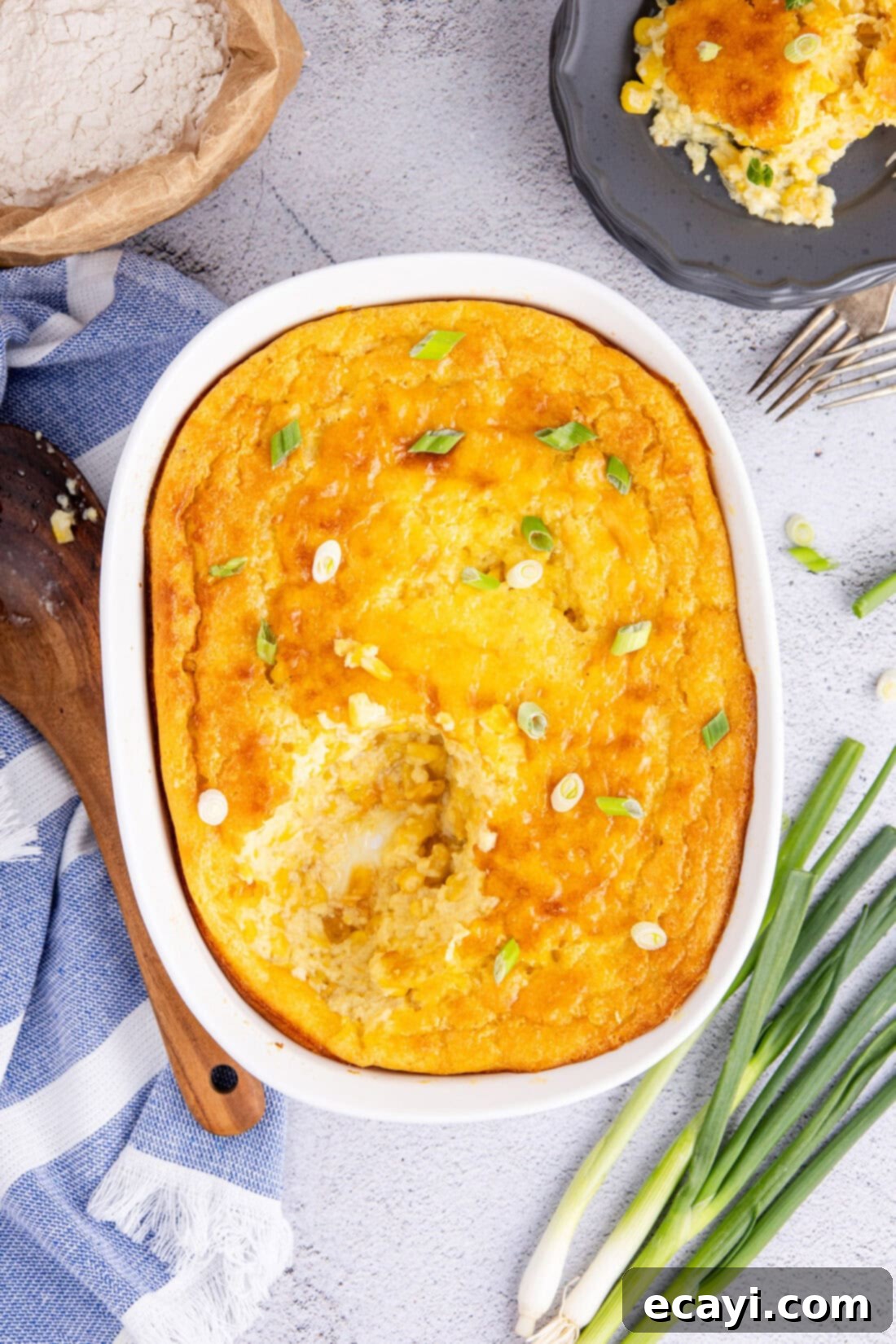 Creamy Golden Corn Bake 2 Golden brown Corn Pudding in a rectangular baking dish with a serving removed, showcasing its creamy texture