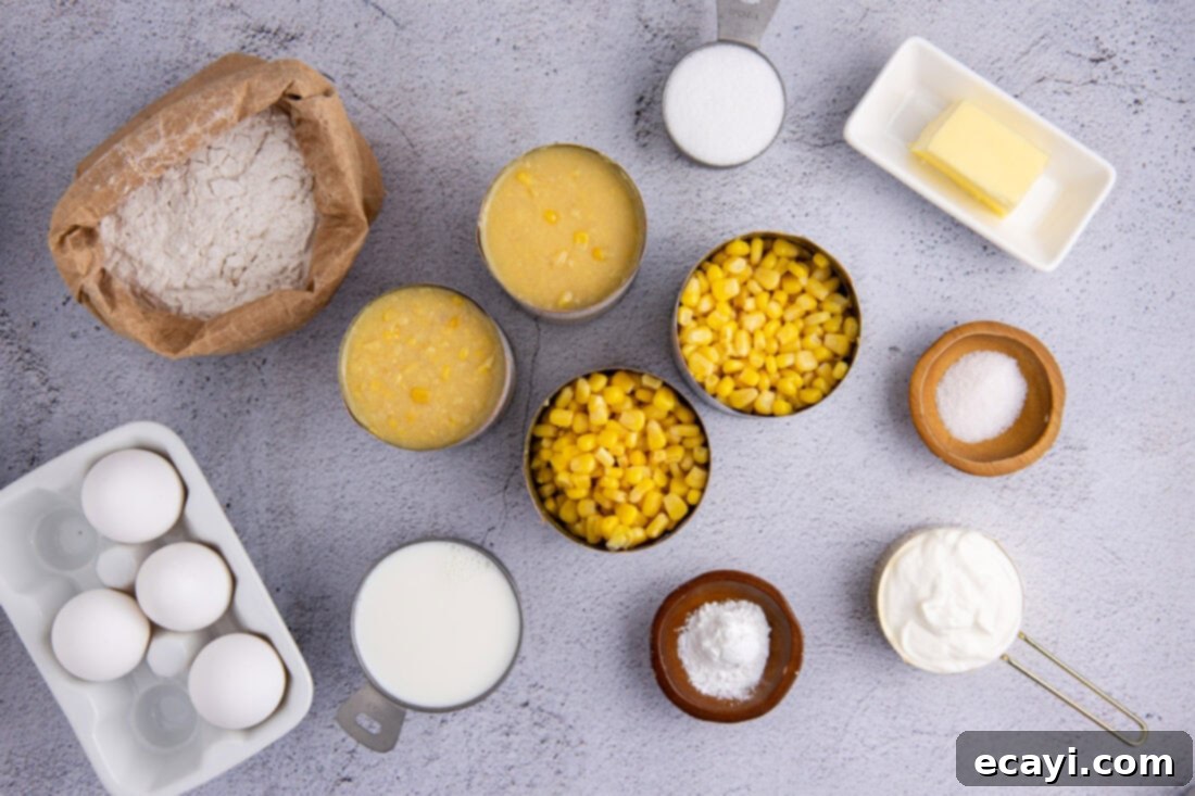 Creamy Golden Corn Bake 4 A flat lay photograph showcasing all the ingredients required for making homemade Corn Pudding, including cans of corn, eggs, milk, flour, sugar, butter, and sour cream