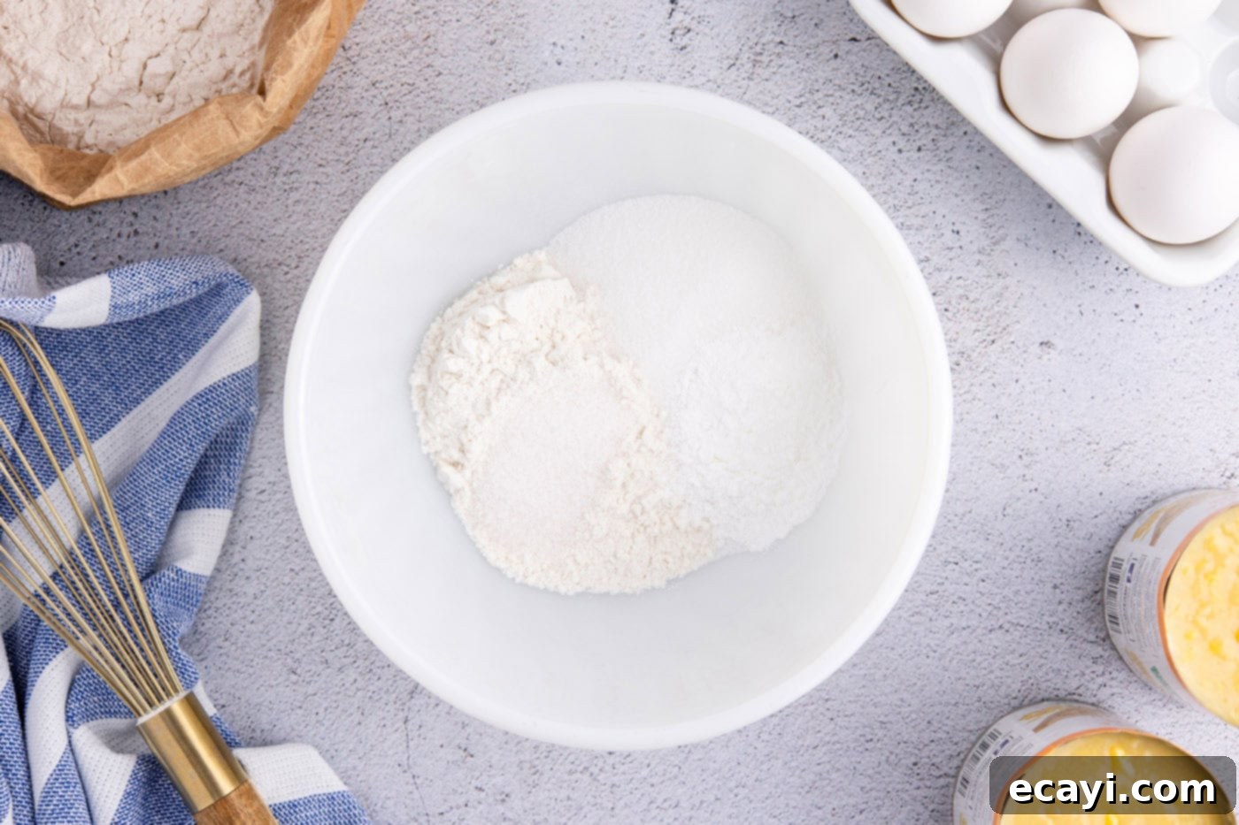 Creamy Golden Corn Bake 5 A medium mixing bowl containing all-purpose flour, granulated sugar, baking powder, and salt, perfectly combined for the dry ingredients of the corn pudding