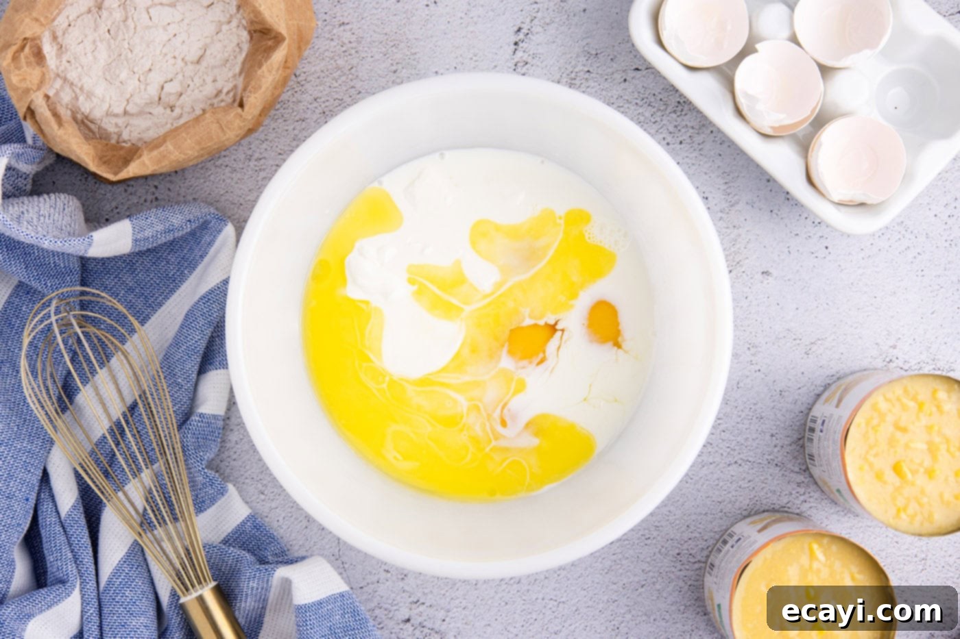 Creamy Golden Corn Bake 6 A large mixing bowl containing a smooth mixture of eggs, whole milk, melted butter, and sour cream, ready for the dry ingredients