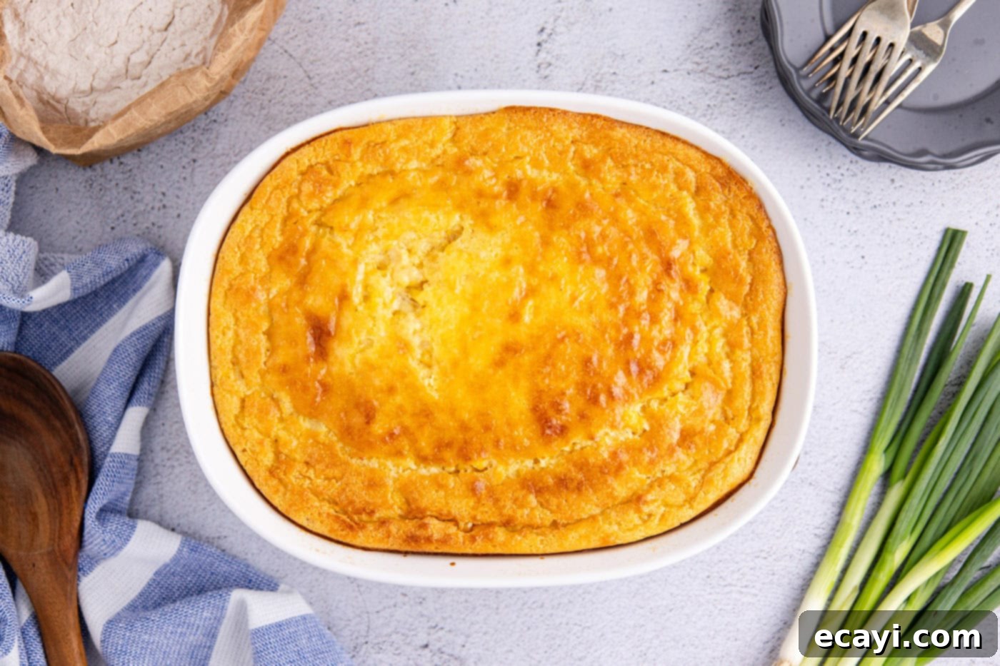 Creamy Golden Corn Bake 10 A close-up shot of a freshly baked, golden-brown corn pudding in a casserole dish, steam gently rising, ready to be served
