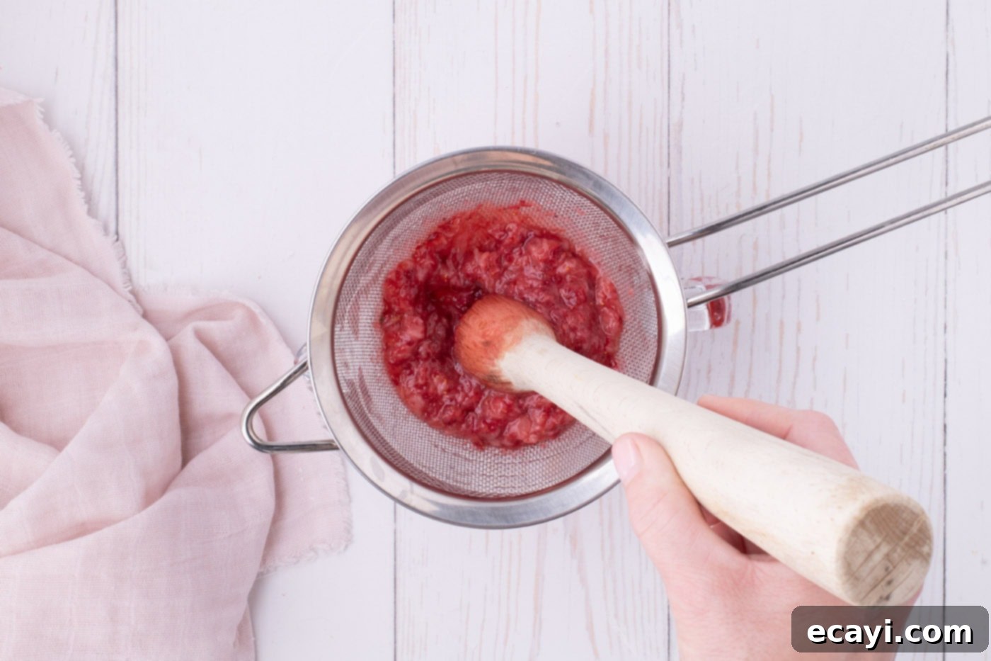 Luscious Strawberry Pound Cake 14 Muddling diced strawberries through a fine mesh sieve into a bowl to extract fresh strawberry juice for the glaze.