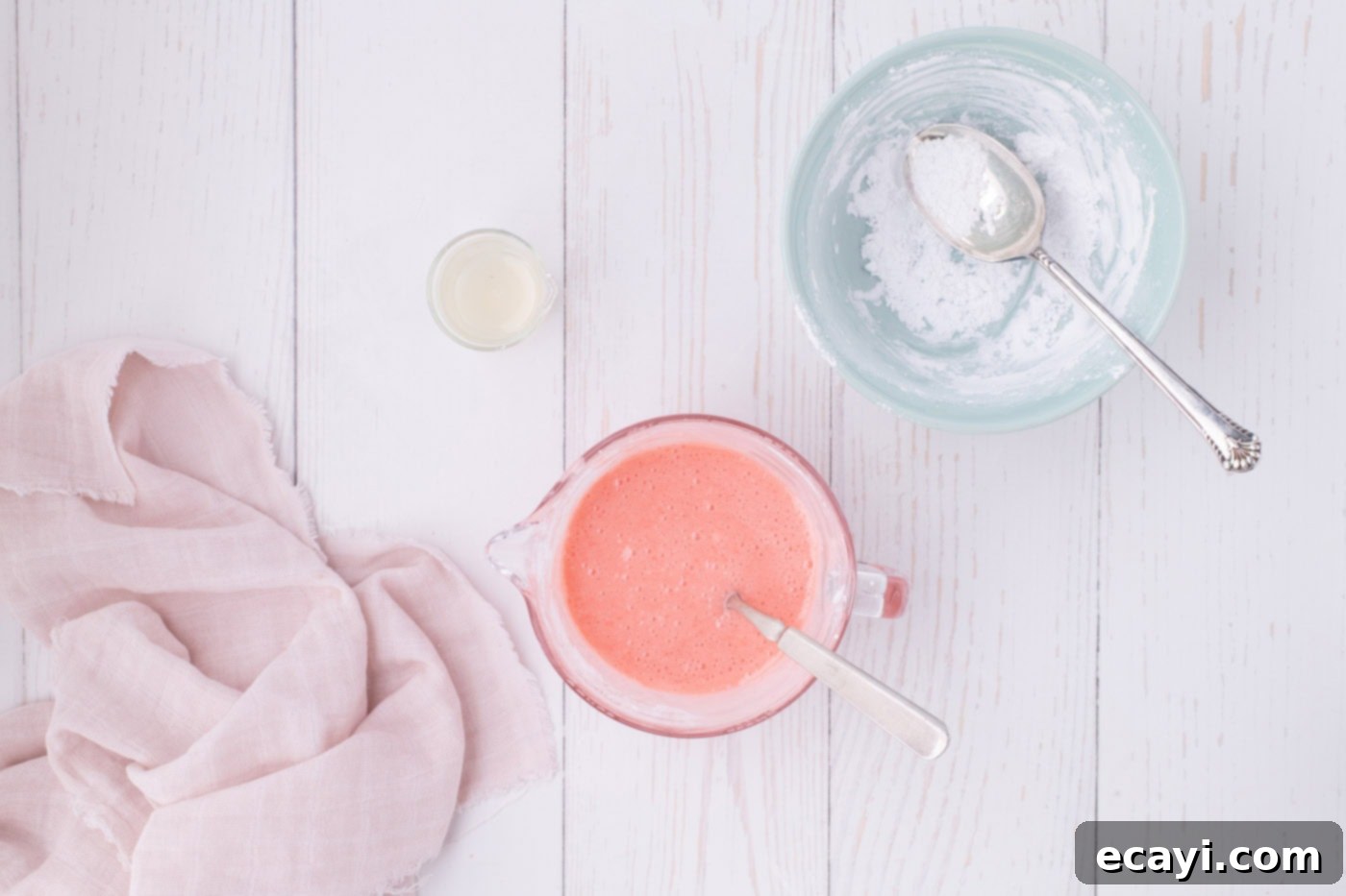 Luscious Strawberry Pound Cake 16 Smooth and easy strawberry glaze with a perfect pink hue, ready to be poured, held in a measuring cup.
