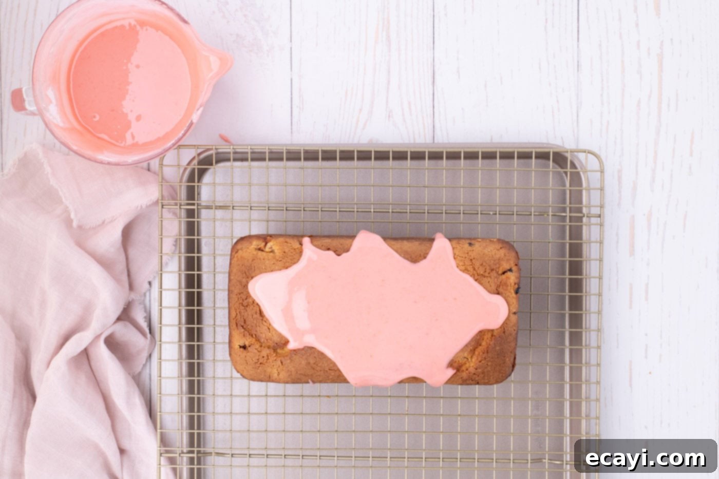 Luscious Strawberry Pound Cake 17 Vibrant pink strawberry glaze being slowly poured over the top of a freshly baked pound cake, creating beautiful drips down the sides.