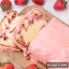 Luscious Strawberry Pound Cake 19 A perfectly sliced piece of Strawberry Pound Cake, garnished with fresh strawberries and a delicate pink glaze.